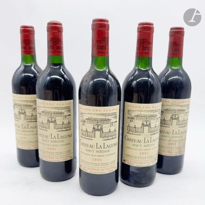 quatre bouteilles de vin rouge posées les unes à côté des autres sur une surface blanche