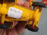 a person holding a yellow toy truck in their hand