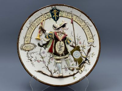 une image représentant une assiette décorative sur laquelle figure un homme tenant une épée et un bouclier