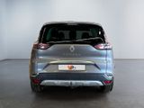 the rear end of a silver car in a room with a white wall