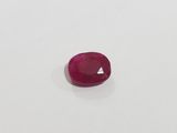 a red ruby stone on a white surface