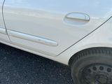 une petite voiture blanche garée sur le bord de la route