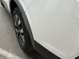 a close up of a white car parked in a parking lot