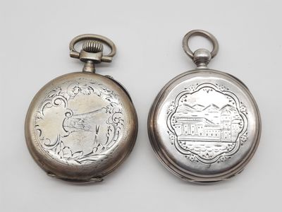 deux montres de poche en argent posées côte à côte sur une surface blanche
