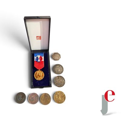 une petite boîte contenant des pièces de monnaie et une médaille