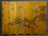 a large yellow screen with birds flying over a tree
