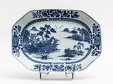 blue and white platter with a landscape scene on it