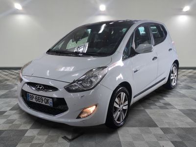 the small white car is parked in a large room