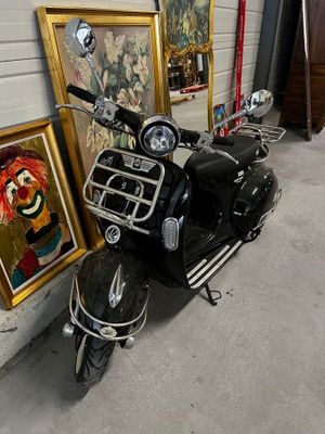 un scooter garé devant un mur orné de dessins