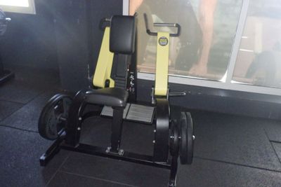 un appareil de fitness noir et jaune posé sur un sol noir