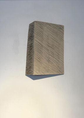 une image représentant un bloc de bois posé sur une surface blanche