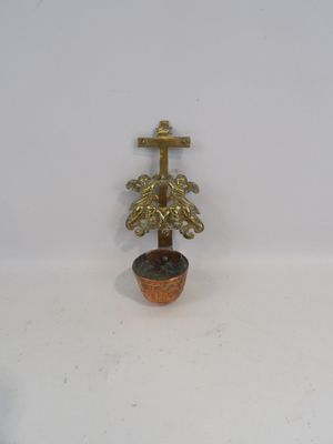 une petite plante en pot sur laquelle est dessinée une croix