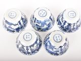 four blue and white vases sitting on top of a white surface