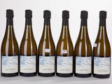 six bottles of wine are lined up in a row on a white surface