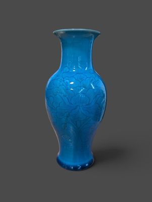 un vase bleu posé sur une surface grise