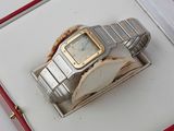 une montre en argent et en or rangée dans un coffret rouge