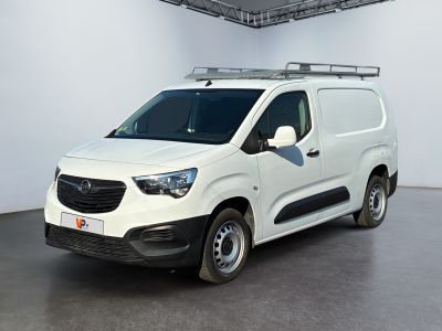 La camionnette blanche est garée dans une grande pièce équipée d'une galerie de toit.