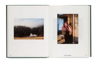 un livre ouvert sur lequel figure l'image d'une femme debout au bord d'un lac