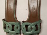 a pair of green sandals on a white surface