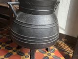 a black pot sitting on top of a wooden chair