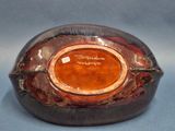 a close up of a brown and black bowl on a blue surface
