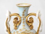 a blue and gold vase sitting on a table