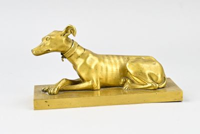 statue d'un chien couché sur un socle en bois