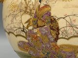 a vase that has a woman in a kimono dress on it