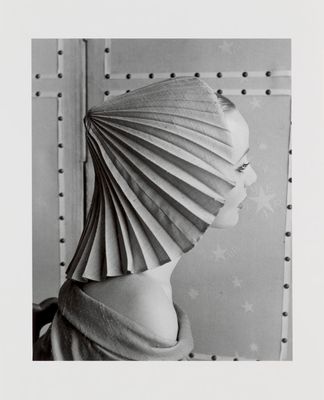 black and white photograph of a woman with a paper hat on her head