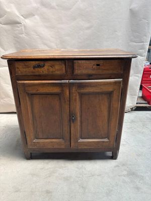 une vieille armoire en bois à deux tiroirs et deux portes