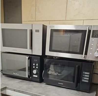 quatre fours à micro-ondes posés sur un plan de travail dans une cuisine