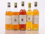 four bottles of different types of alcohol are lined up on a white surface