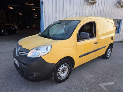 the small yellow van is parked in front of a building
