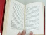 a person holding a book open on a table