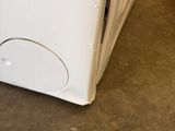 a white refrigerator sitting in a room with a red chair