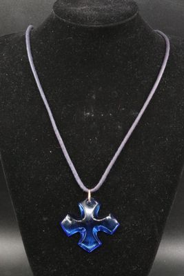 a close up of a necklace on a mannequin with a cross on it