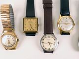several different types of watches are lined up on a white surface
