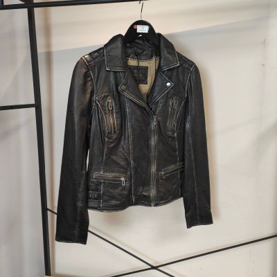 une veste en cuir noir accrochée à un porte-vêtements dans une pièce