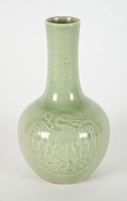 a green vase that is sitting on a white surface