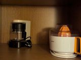 une cafetière et un extracteur de jus posés sur une étagère dans une cuisine