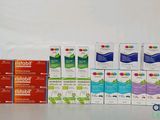 plusieurs boîtes de dentifrice et du dentifrice posés sur une table