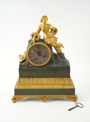 a gold and green clock with a statue on it