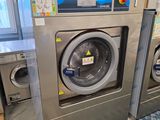 une machine à laver et un sèche-linge dans une pièce dont le sol est recouvert d'un tapis
