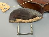 a violin that is sitting on a table next to a piece of wood