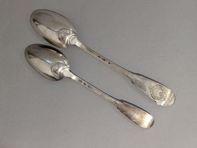 deux cuillères en argent posées sur une table l'une à côté de l'autre