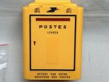 une boîte aux lettres jaune sur laquelle figure une flèche rouge