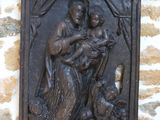 une statue représentant une femme tenant un bébé et un chien