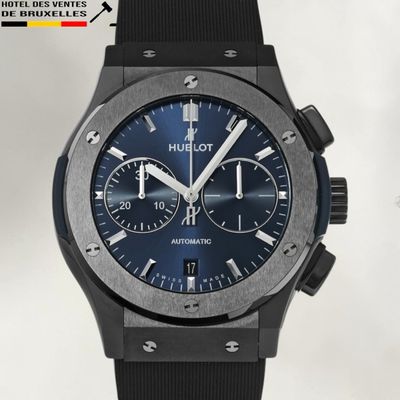 un gros plan d'une montre au cadran bleu sur fond blanc