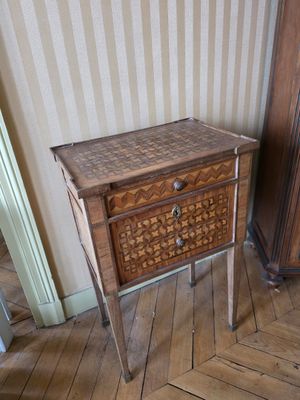 une petite table avec un tiroir dans le coin d'une pièce