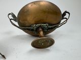 a small brass object with a handle and a spoon